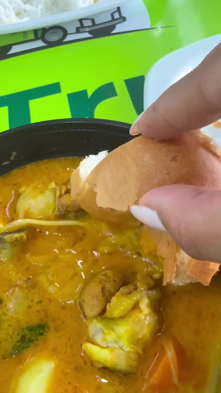 Bread dipped into Mum's special Vietnamese chicken curry, with potato and carrot, on our green table
